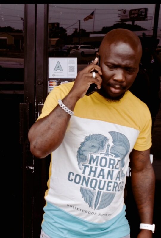 Man wearing More Than A Conqueror T-shirt